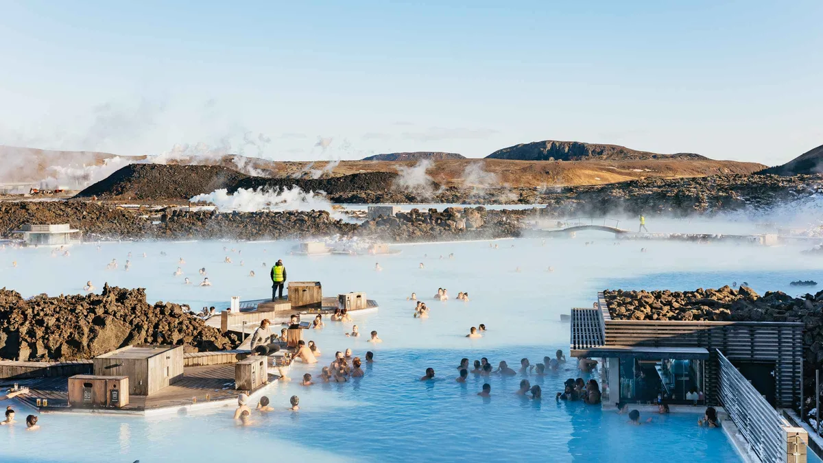 Travelers soaking in the milky blue geothermal water of the Blue Lagoon after a Fagradalsfjall volcano tour, Iceland